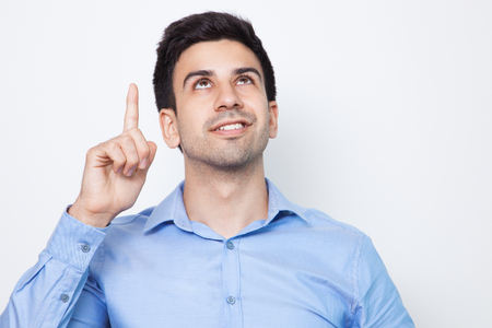 Smiling Young Handsome Man Pointing Upwardsの写真素材