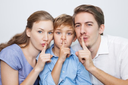 Portrait of serious family holding finger on lipsの写真素材