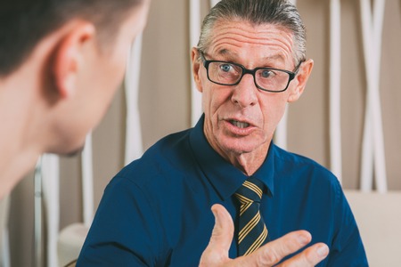 Astonished Senior Businessman Talking to Young Manの写真素材