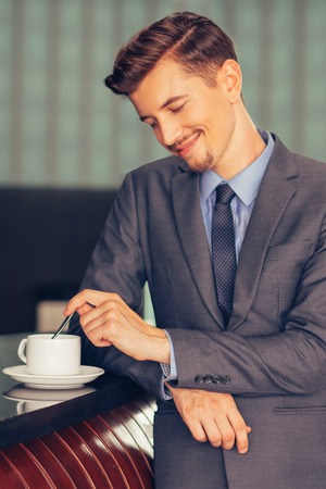 Content Middle-aged Businessman Stirring Coffeeの写真素材
