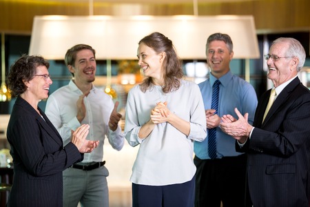 Coworkers Applauding to Happy Young Female Managerの写真素材