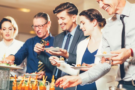 Happy Business People Serving Themselves in Buffetの写真素材