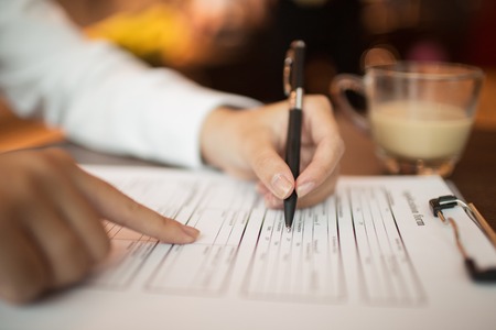 Female hand filling in form and pointing at itの写真素材