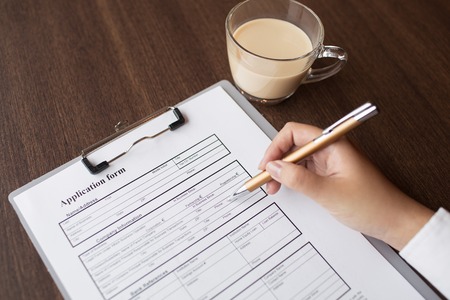 Female executive reading application form at tableの写真素材