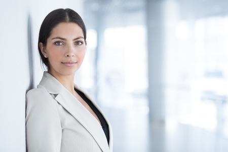 Confident Business Lady Leaning on Wall in Hall