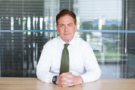 Portrait of serious businessman sitting in officeの写真素材