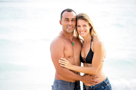 Portrait of smiling couple embracing at seasideの写真素材