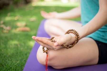 Hand of meditating woman holding rosary beadsの写真素材