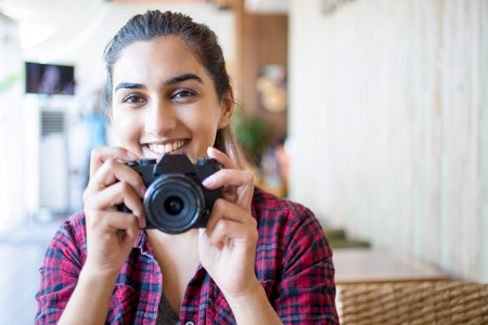 Cheerful female photographer posing for camera