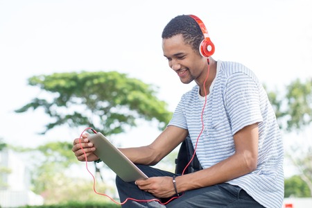Smiling student surfing net and listening to musicの写真素材