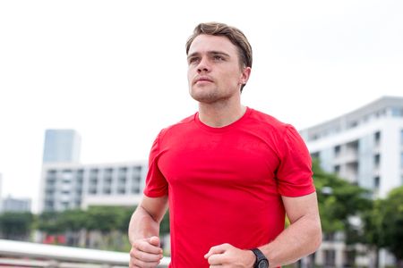 Closeup of Sporty Young Man Running Outdoorsの写真素材