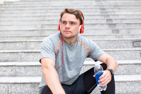 Confident Sportsman Listening to Music on Stairsの写真素材
