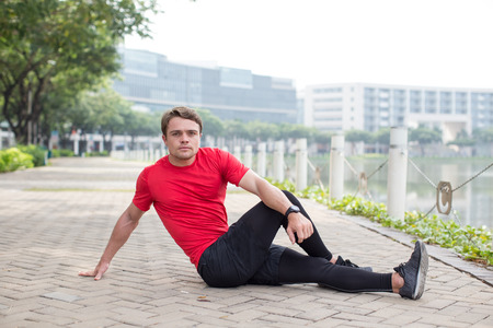 Sporty Young Man Stretching Body Outdoorsの写真素材