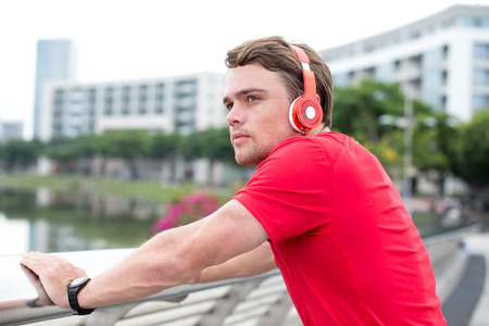 Sporty Man Listening to Music and Relaxing Outdoorsの写真素材
