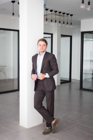 Confident businessman standing in office hallの写真素材