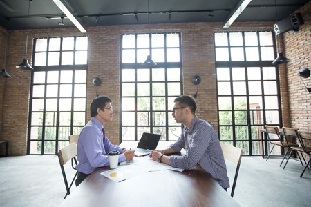 Serious Partners Negotiating in Loft Officeの写真素材