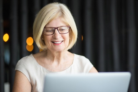 Closeup of Smiling Senior Woman Working on Laptop