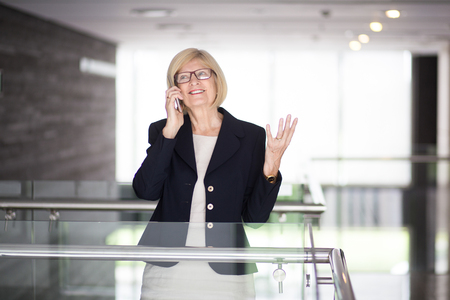 Excited Senior Business Lady Talking on Phoneの写真素材