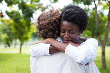Smiling young woman embracing her boyfriendの写真素材