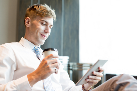 Content Business Man With Cup and Tabletの写真素材