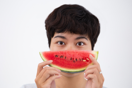 Closeup of Serious Asian Woman Holding Watermelonの写真素材