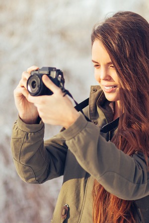 Young Pretty Woman Photographing in Winter Forestの写真素材