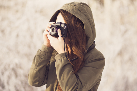 Young Woman Taking Photographs in Winter Forestの写真素材