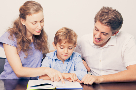 Smiling Mother and Father Teaching Son to Readの写真素材