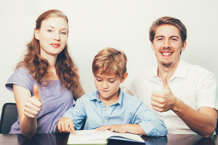 Mom, Dad and Son Reading Book With Thumbs Upの写真素材