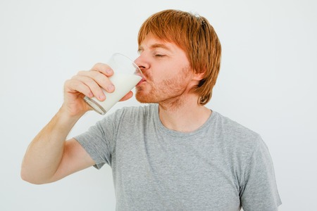 Handsome Red-haired Man Drinking Milk From Glassの写真素材