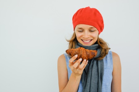 Smiling Pretty Woman Looking at Tasty Croissantの写真素材