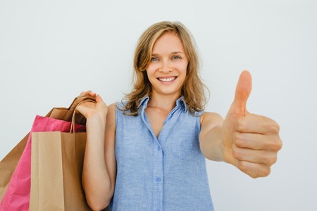 Smiling Woman Holding Bags and Showing Thumb Upの写真素材