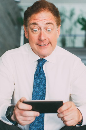 Amazed mature manager using phoneの写真素材