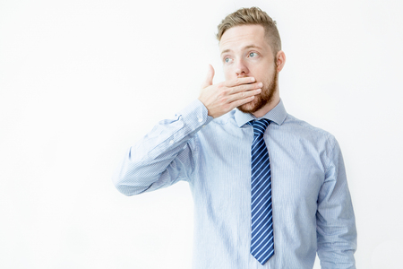Surprised Young Business Man Covering Mouthの写真素材