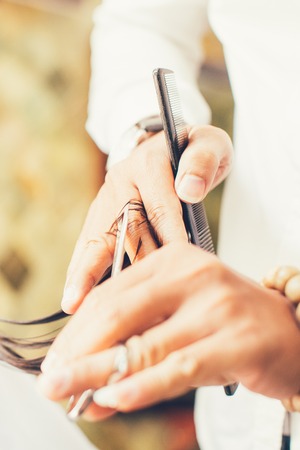 Close-up of hairdresser hand cutting female hairの写真素材