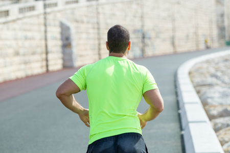 Closeup Back View of Strong Man Running on Roadの写真素材