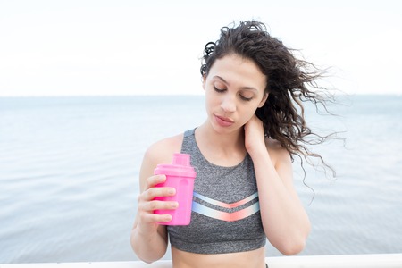Sexy Pretty Sporty Girl Drinking by Riverの写真素材