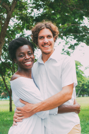 Portrait of happy young couple in white embracingの写真素材