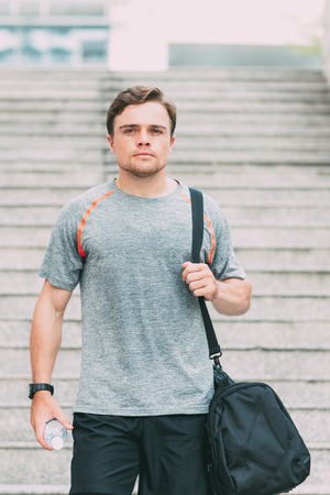 Sporty Man With Gym Bag and Water on Stairs