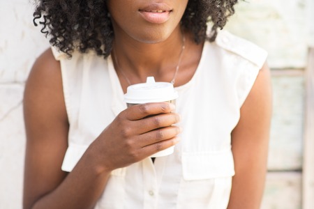 Close-up of smiling woman drinking coffee outdoorsの写真素材