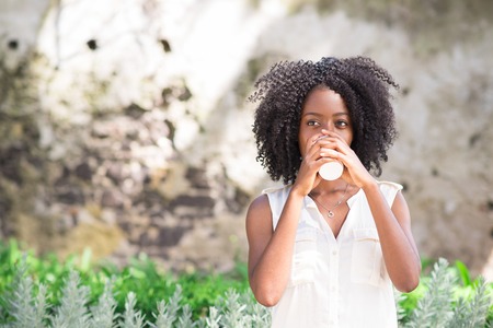Mindful young woman drinking coffee outdoorsの写真素材