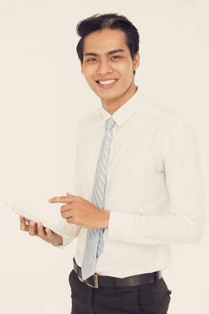 Smiling handsome Asian manager with modern deviceの写真素材