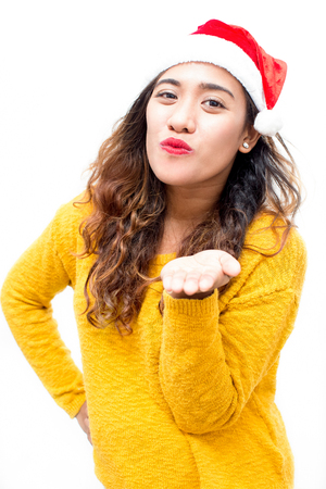 Cheerful pretty girl in Santa hat blowing kissの写真素材