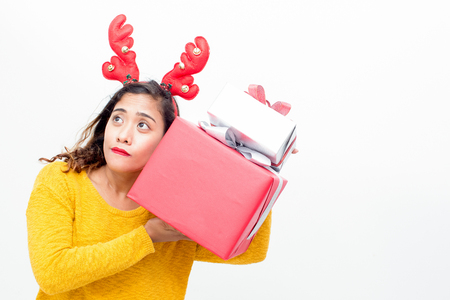 Curious pretty woman shaking Christmas giftsの写真素材