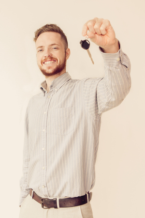 Happy sales manager holding car or house keyの写真素材
