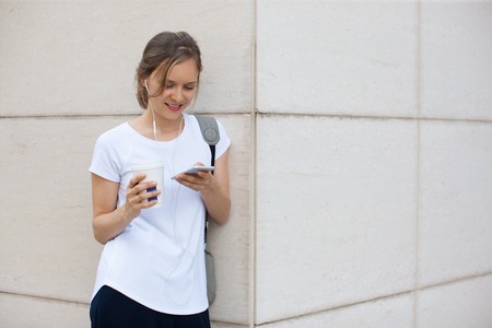 Smiling Woman Texting on Smartphone Outdoors