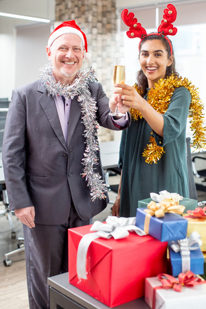 Positive colleagues raising champagne fluteの写真素材