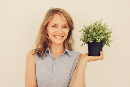 Smiling Young Beautiful Woman Holding Pot Plantの写真素材