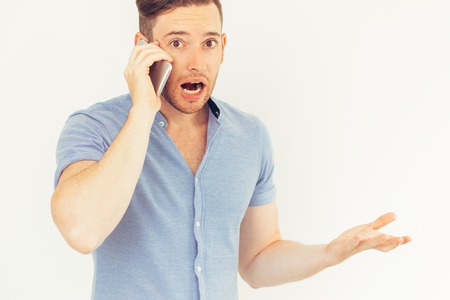 Astonished handsome guy talking on phone
