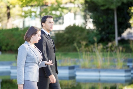 Serious Business Colleagues Walking in Parkの写真素材